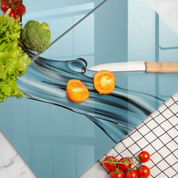 Skärbräda glas Vatten på en blå bakgrund