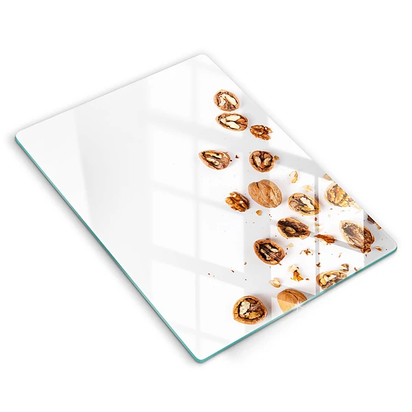 Glasskärbräda med motiv av nötter på vit bakgrund