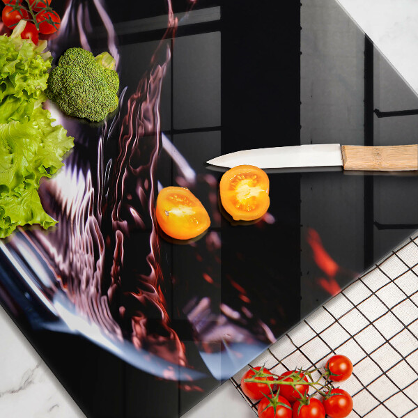 Skärbräda av glas Ett glas rött vin