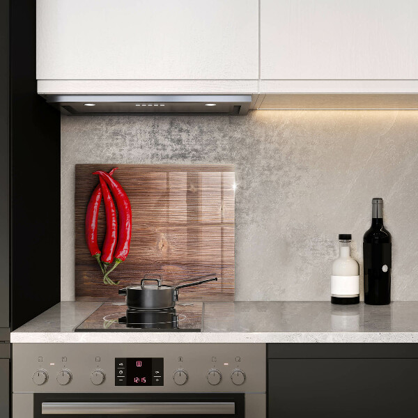 Skärbräda av glas Chilipeppar på trä