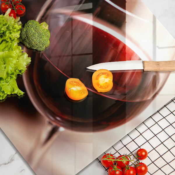 Skärbräda av glas Ett glas rött vin