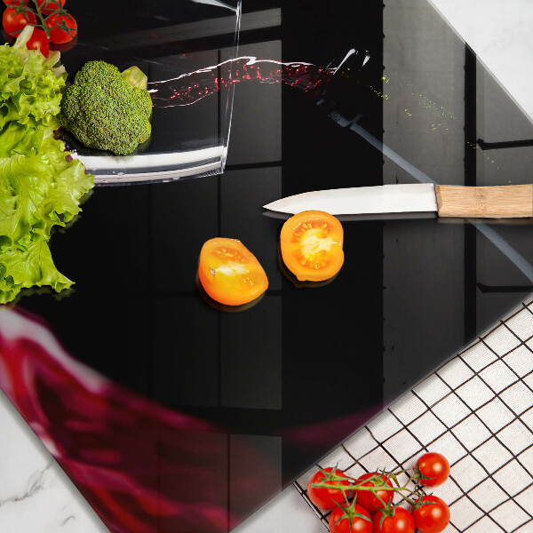 Skärbräda av glas Ett glas rött vin